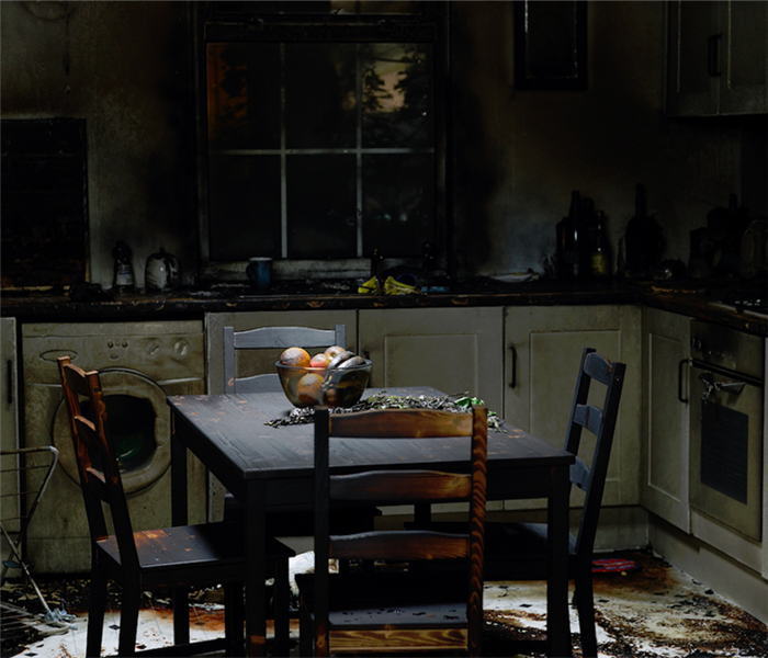 a fire damaged kitchen with soot covering everything